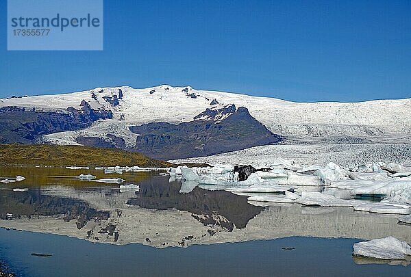 Eisberge und Gletscher spiegeln sich in einem See  Gletscher und Berge im Hintergrund  Fjallsarlon  Vatnajökull Nationalpark  Island  Europa