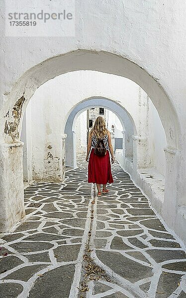 Weiße Torbögen zwischen Häusern  Junge Frau mit Rotem Kleid in der Altstadt von Lefkes  Paros  Kykladen  Griechenland  Europa