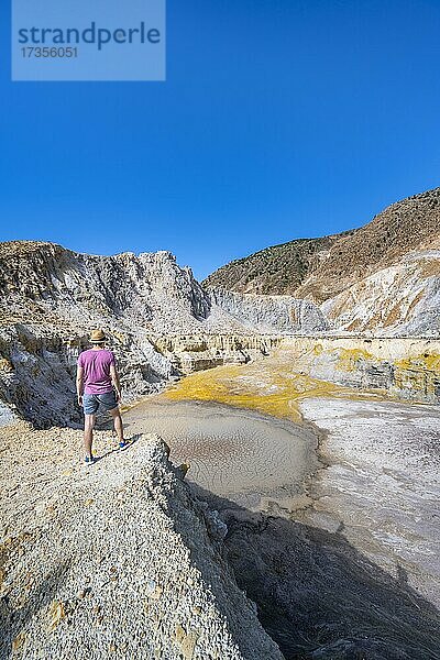 Junger Tourist an einem Krater  Vulkan Caldera mit Bimssteinfeldern  gelb gefärbte Schwefelsteine  Alexandros Krater  Nisyros  Dodekanes  Griechenland  Europa