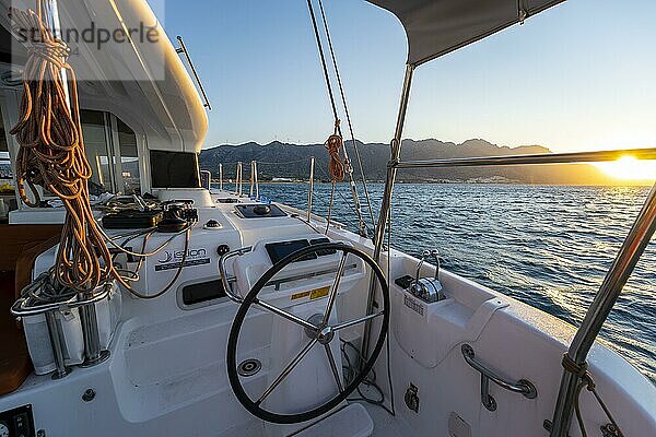 Steuerrad im Cockpit an Deck eines Segel-Katamaran  Seile beim segeln  Sonnenuntergang  Segeltörn  Dodekanes  Griechenland  Europa