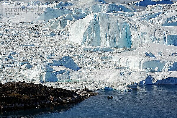 Kleines Fischerboot vor riesigen Eisbergen  Arktis  Eisfjord  Diskobucht  Grönland  Dänemark  Nordamerika