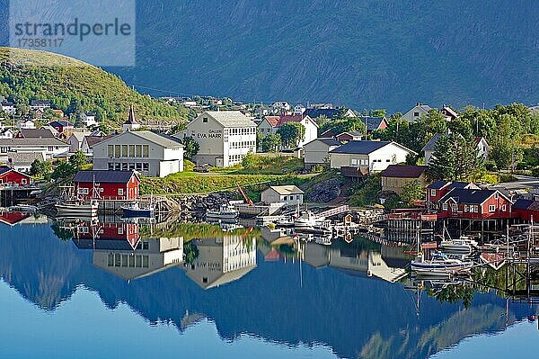 Holzhäuser und schroffe Berge spiegeln sich perfekt im Wasser  ruhige Fjordlandschaft  Reine  Reinefjorden  Nordland  Lofoten  Norwegen  Europa