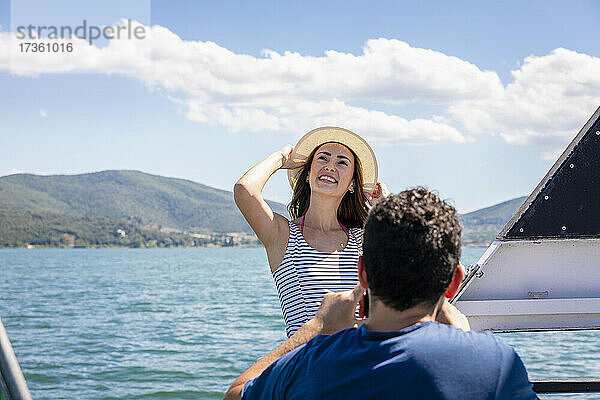 Mann mit glücklicher junger Freundin auf einem Ausflugsboot an einem sonnigen Tag