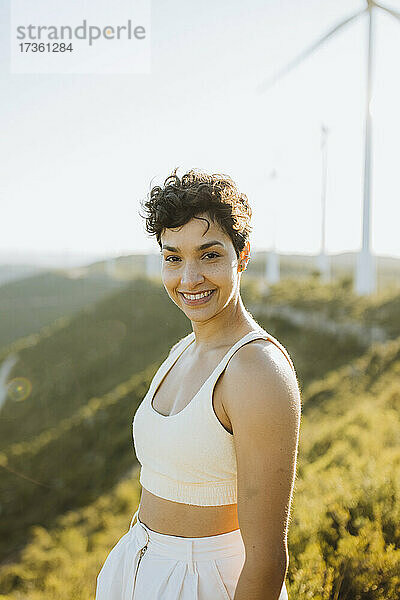 Lächelnde Frau auf einem Berg stehend
