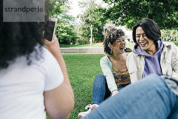 Glückliche männliche und weibliche Freunde im öffentlichen Park