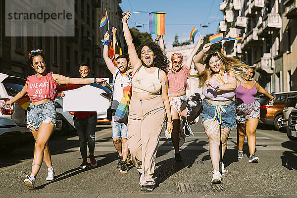 Fröhliche weibliche und männliche Aktivisten  die an einem sonnigen Tag auf der Straße für Gleichberechtigung protestieren