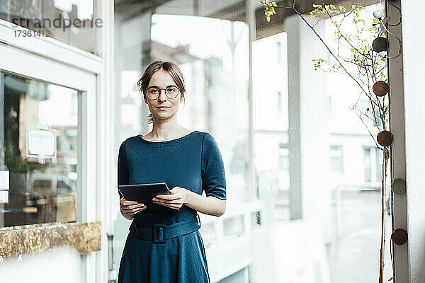 Geschäftsfrau mit digitalem Tablet in einem Café stehend
