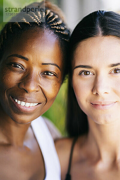 Gemeinsam lächelnde multiethnische Freundinnen