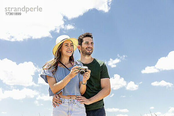 Glückliches Paar mit Kamera an einem sonnigen Tag