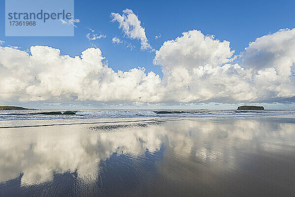 Wolken  die sich im Küstenwasser am Minnamurra Beach spiegeln  mit Stack Island im Hintergrund