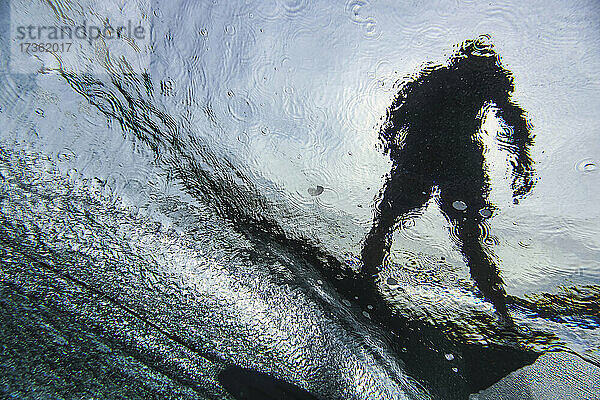 Unterwasseransicht eines jungen Mannes beim Surfen im Süd-Male-Atoll