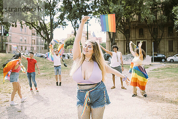 Junge Frau bei Pride-Veranstaltung mit Freunden im Park