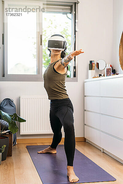 Frau benutzt Virtual-Reality-Headset beim Training zu Hause