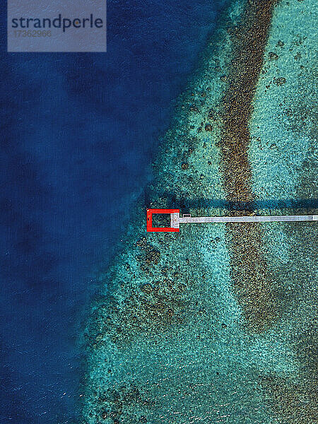 Roter Steg über türkisfarbenem Meer auf der Insel Thulusdhoo im Kaafu-Atoll  Malediven