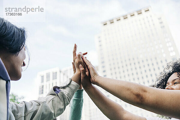 Männliche und weibliche Freunde geben sich gegenseitig High Five