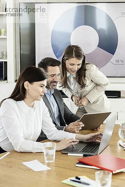 Geschäftsmann nutzt digitales Tablet mit Kollegen im Büro