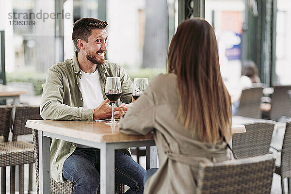 Glücklicher Mann im Gespräch mit seiner Freundin in einer Bar