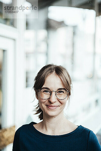 Lächelnde Frau mit braunem Haar und Brille
