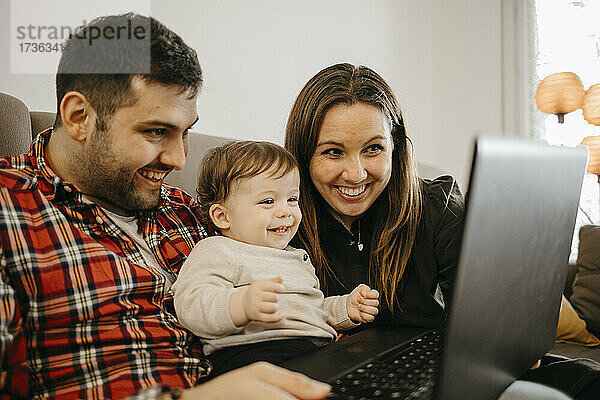 Glückliche Familie während eines Videoanrufs über den Laptop zu Hause