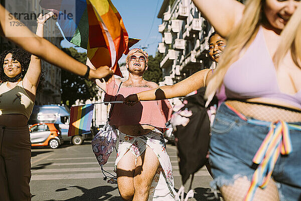 Lächelnde männliche und weibliche Demonstranten beim Marschieren auf der Straße