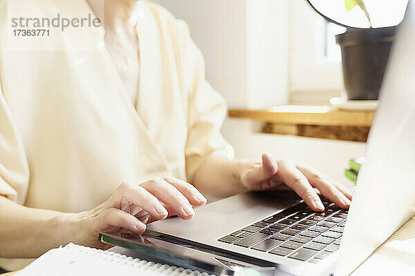 Reife Frau  die einen Laptop benutzt  während sie im Büro zu Hause arbeitet