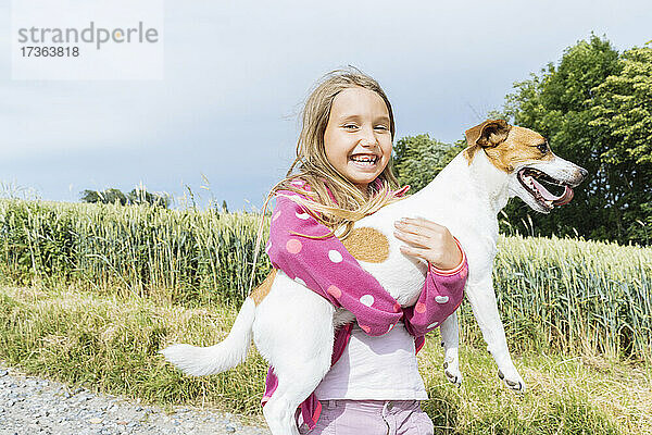 Heiteres Mädchen mit Hund an einem sonnigen Tag