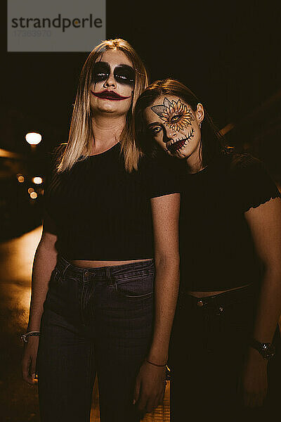 Frauen mit zeremoniellem Make-up stehen an Halloween auf der Straße