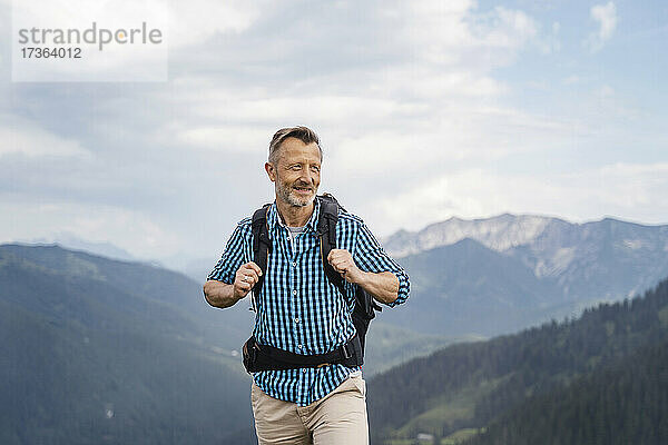 Älterer Mann mit Rucksack beim Wandern auf einem Berg