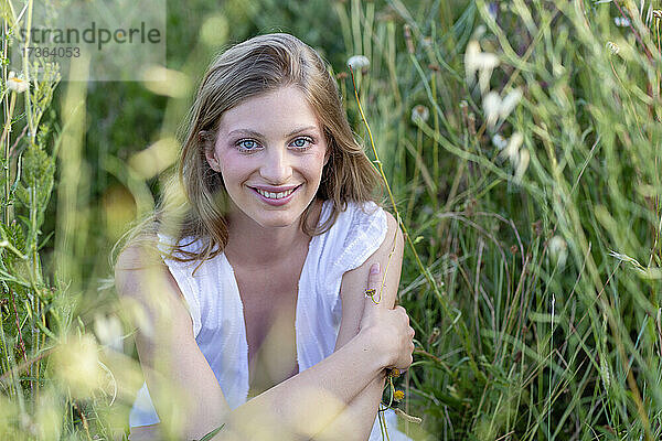 Lächelnde junge Frau auf einem landwirtschaftlichen Feld