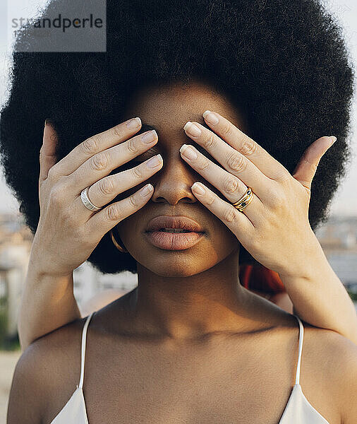 Junge Frau bedeckt die Augen ihrer Afro-Freundin