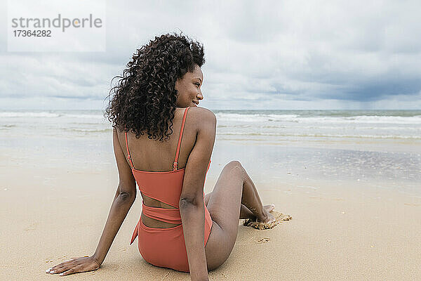 Frau schaut weg  während sie am Strand sitzt