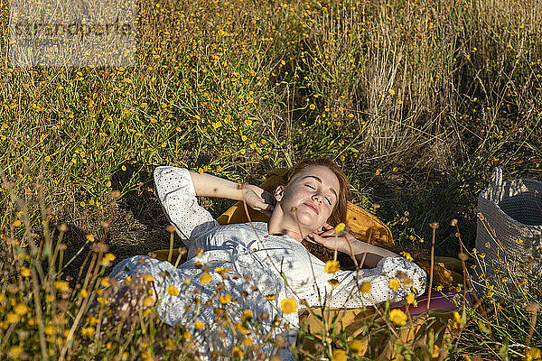 Junge Frau entspannt sich auf einer Wiese an einem sonnigen Tag