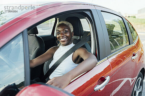 Junge Frau lächelnd während der Fahrt im Auto