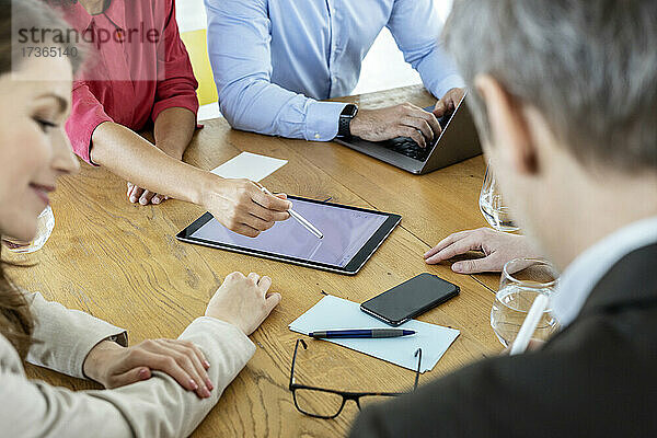 Geschäftsleute verwenden während einer Besprechung ein digitales Tablet auf dem Tisch