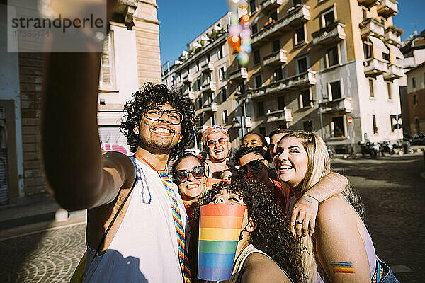 Lächelnde männliche und weibliche Freunde  die an sonnigen Tagen ein Selfie auf der Straße machen