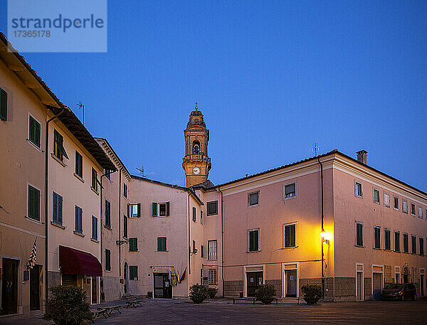 Italien  Provinz Pisa  Pomarance  Piazza de Larderel in der Abenddämmerung mit Glockenturm der Kirche San Giovanni Battista im Hintergrund