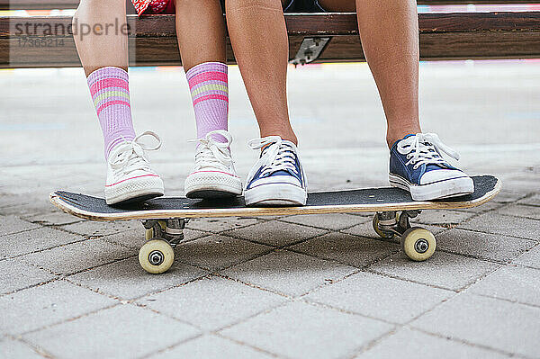 Freunde mit Skateboard auf einer Bank sitzend