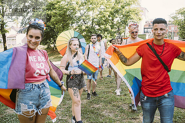 Männliche und weibliche Freunde protestieren bei einer Pride-Veranstaltung im Park