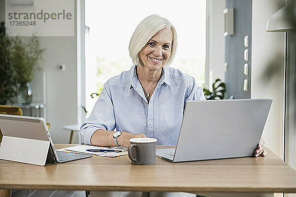 Lächelnde weibliche Fachkraft bei der Arbeit im Heimbüro