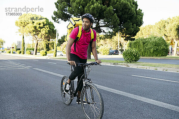Lieferwagenfahrer schaut weg  während er auf der Straße Fahrrad fährt