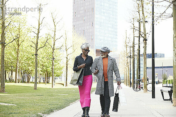 Ehepaar mit Einkaufstüten auf dem Fußweg in der Stadt