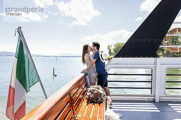 Paar küsst sich im Fährboot stehend