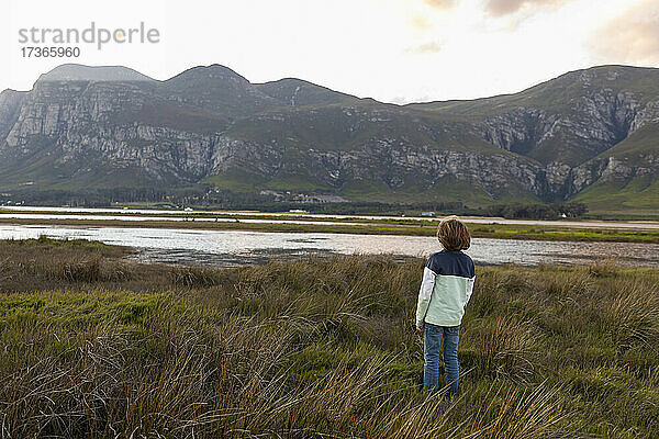 Ein Junge erkundet das Ufer einer Lagune im Schatten der Kleinriver-Bergkette
