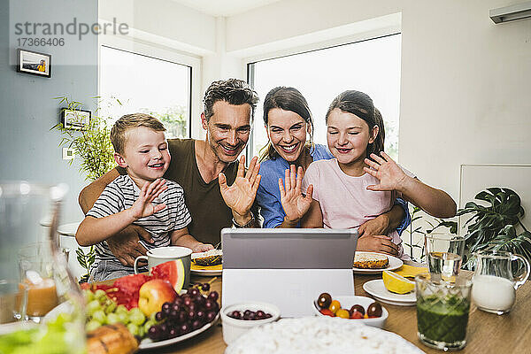 Begrüßung der Familie bei einem Videogespräch über ein digitales Tablet zu Hause