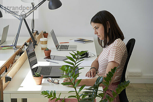 Geschäftsfrau arbeitet am Schreibtisch im Büro