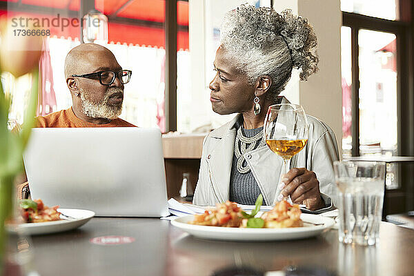 Ehepaar benutzt Laptop im Restaurant