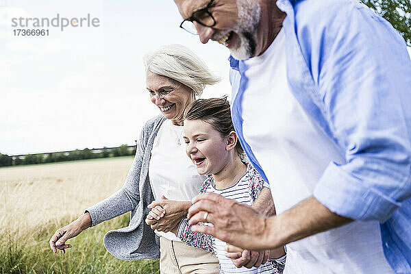Fröhliche Enkelin und Großeltern verbringen gemeinsam ihre Freizeit