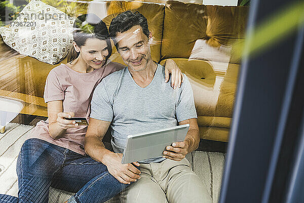 Mann und Frau machen Online-Zahlung auf digitalem Tablet zu Hause