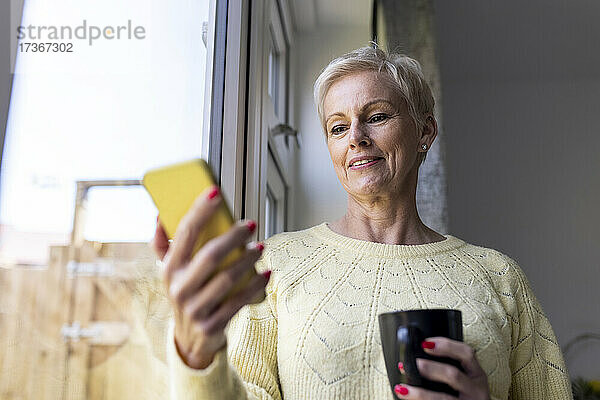 Frau benutzt Smartphone zu Hause