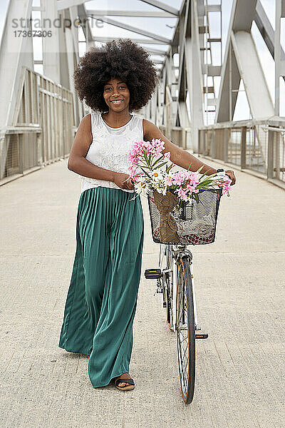 Afro-Frau zu Fuß mit Fahrrad auf Brücke